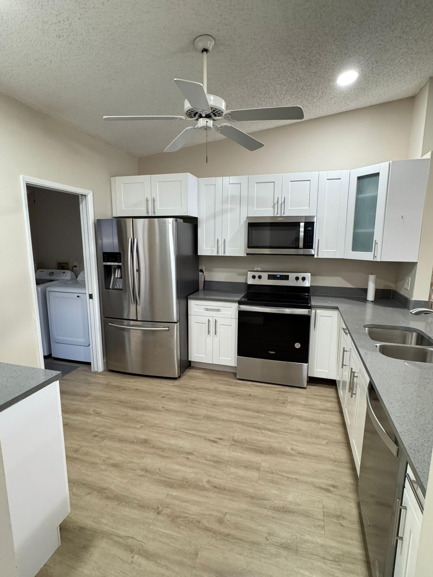 18560 Sunburst Lane, Unit D Boca Raton, FL 33496 - Photo 6 of 28 a kitchen with a refrigerator stove and microwave