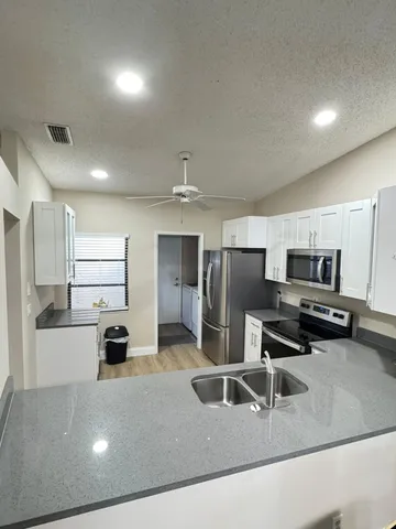a kitchen with kitchen island a sink stainless steel appliances and cabinets
