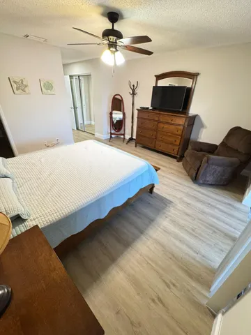 a bedroom with a bed a couch and a chandelier