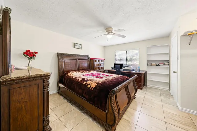 a spacious bedroom with a bed and a chandelier
