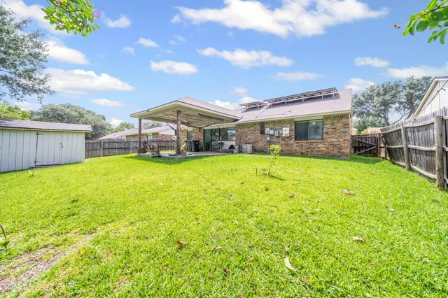 a view of a house with a big yard and large tree