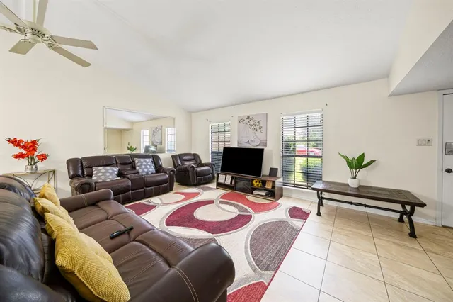 a living room with furniture a flat screen tv and a window