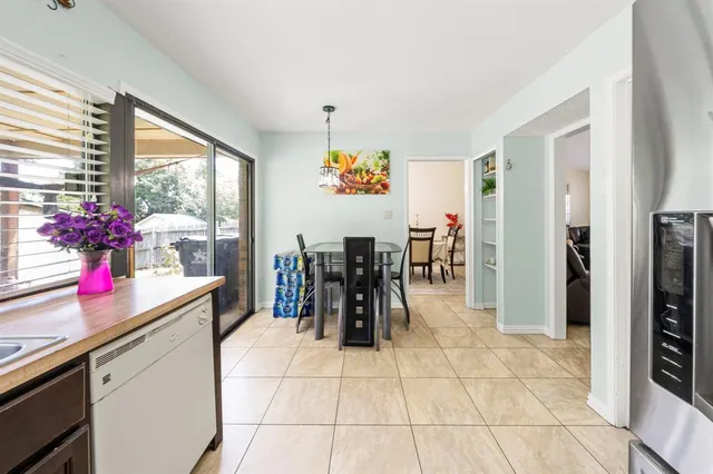 a living room with stainless steel appliances furniture and a large window
