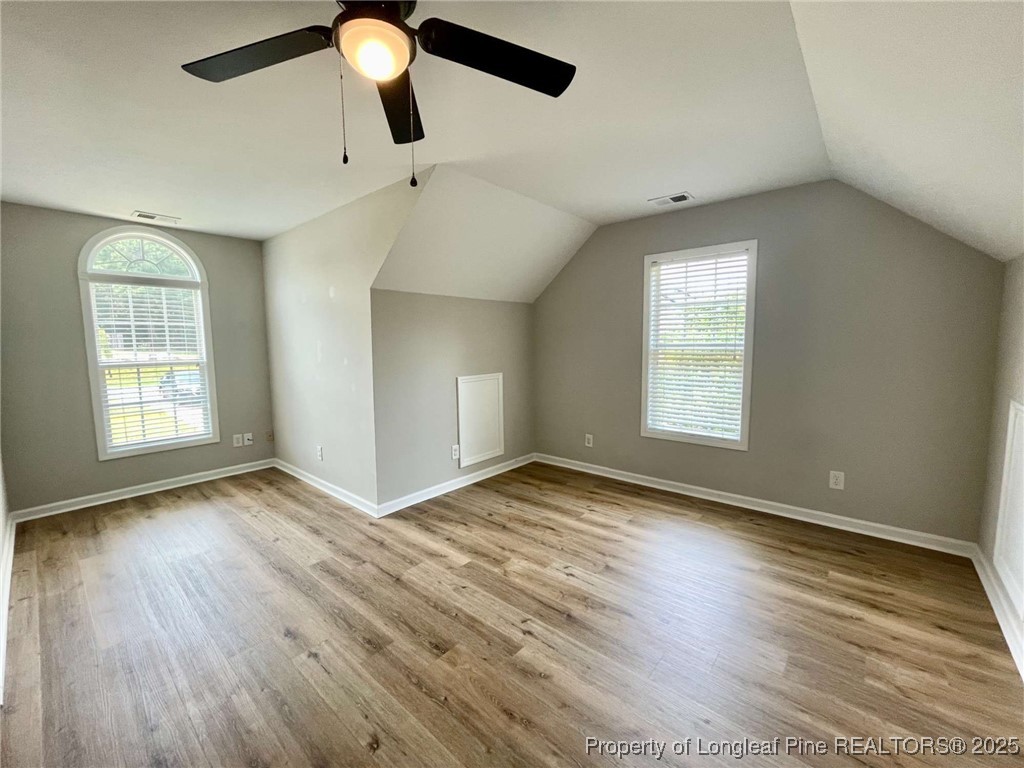 216 Cobblestone Drive Spring Lake, NC 28390 - Photo 16 of 30 an empty room with wooden floor chandelier fan and windows