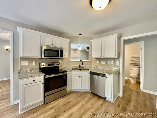 a kitchen with stainless steel appliances granite countertop a stove a sink and a microwave
