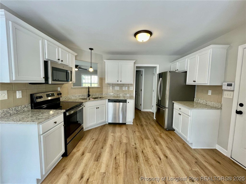 216 Cobblestone Drive Spring Lake, NC 28390 - Photo 25 of 30 a kitchen with granite countertop a refrigerator stove top oven and sink