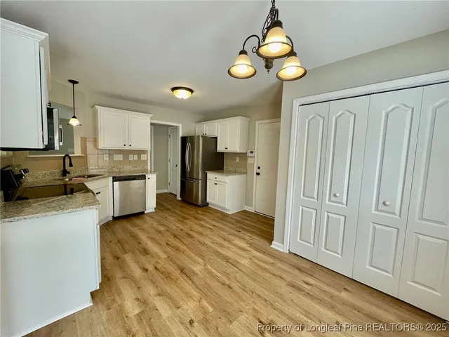 a kitchen with stainless steel appliances granite countertop a refrigerator and a stove top oven