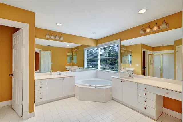 a bathroom with a double vanity sink a mirror and a bathtub