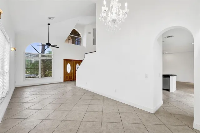 a large white kitchen with a stove a sink a microwave and cabinets