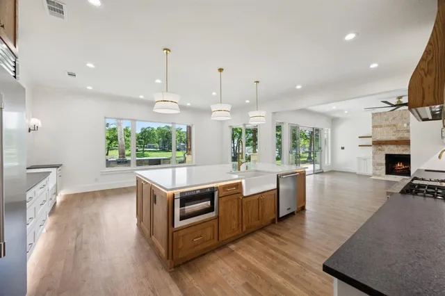 a kitchen with stainless steel appliances granite countertop a stove and a wooden floors