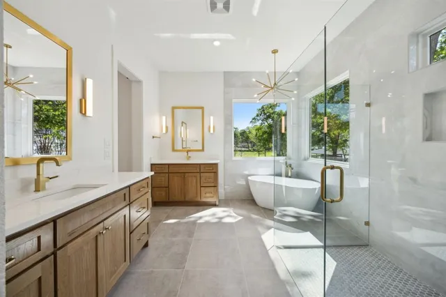 a spacious bathroom with a double vanity sink a large mirror and a bathtub