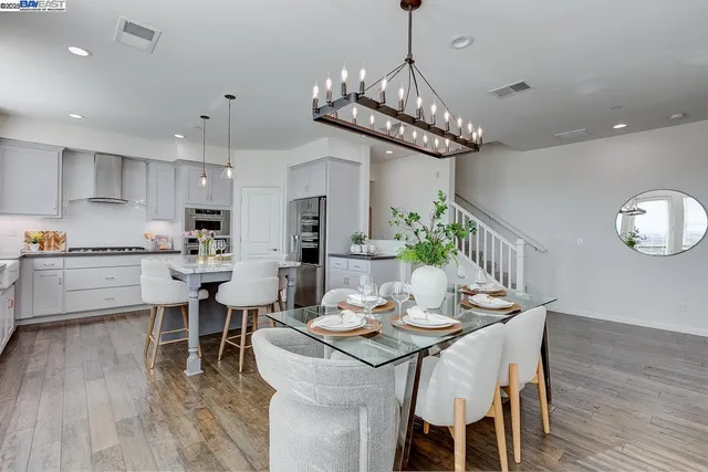a kitchen with a dining table chairs wooden floor and kitchen view