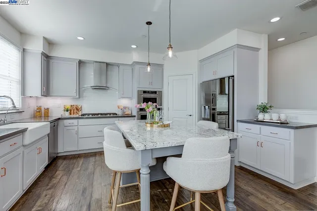 a kitchen with granite countertop white cabinets and stainless steel appliances
