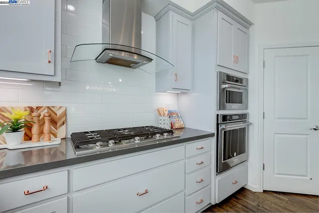 a kitchen with white cabinets and appliances