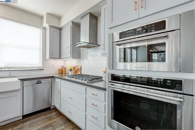 a kitchen with cabinets stainless steel appliances and a window
