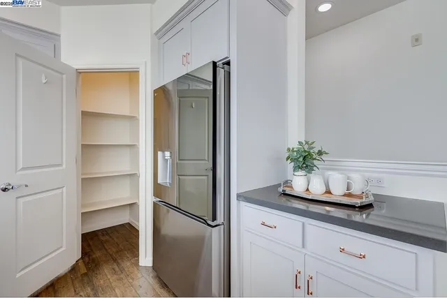 a kitchen with a refrigerator and potted plant