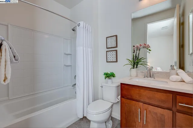 a bathroom with a granite countertop sink a toilet and shower