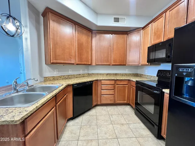 a kitchen with stainless steel appliances granite countertop a sink stove and microwave