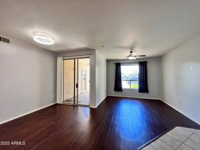 an empty room with wooden floor and windows