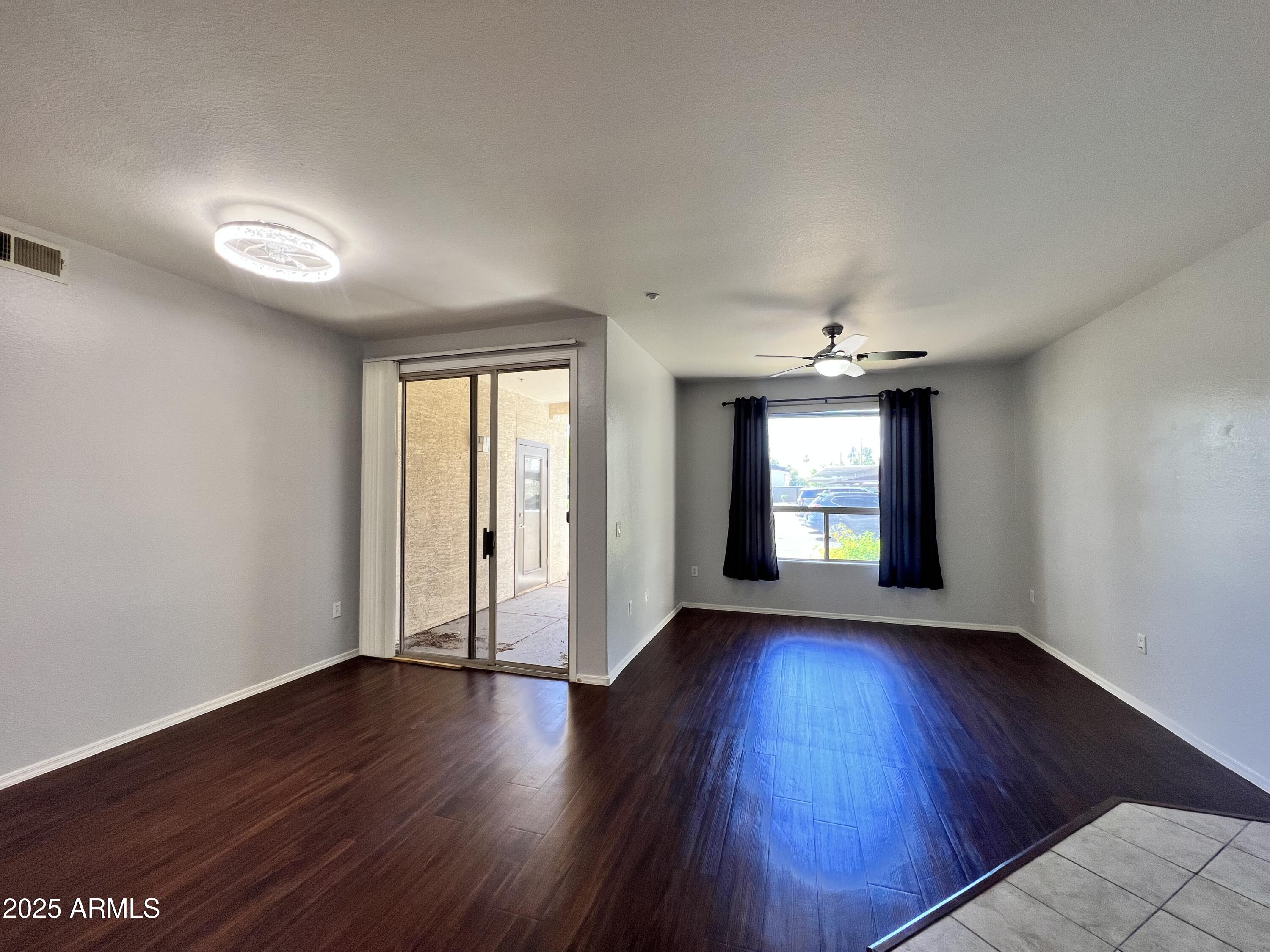 5303 North 7th Street, Unit 132 Phoenix, AZ 85014 - Photo 17 of 32 an empty room with wooden floor and windows