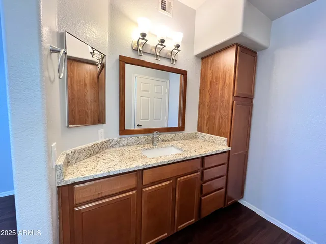 a bathroom with a granite countertop sink and a mirror