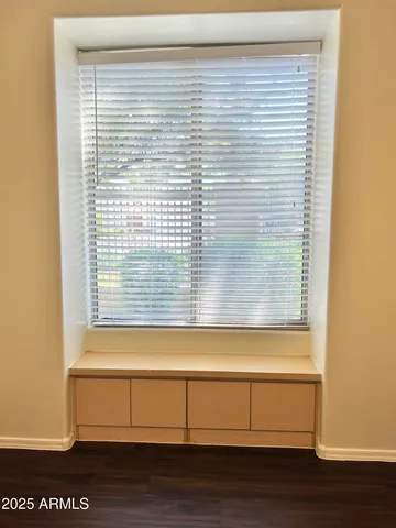 a view of a small space with wooden floor and a window