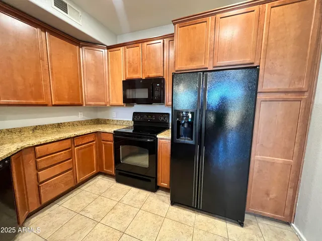 a kitchen with stainless steel appliances granite countertop a refrigerator and a sink