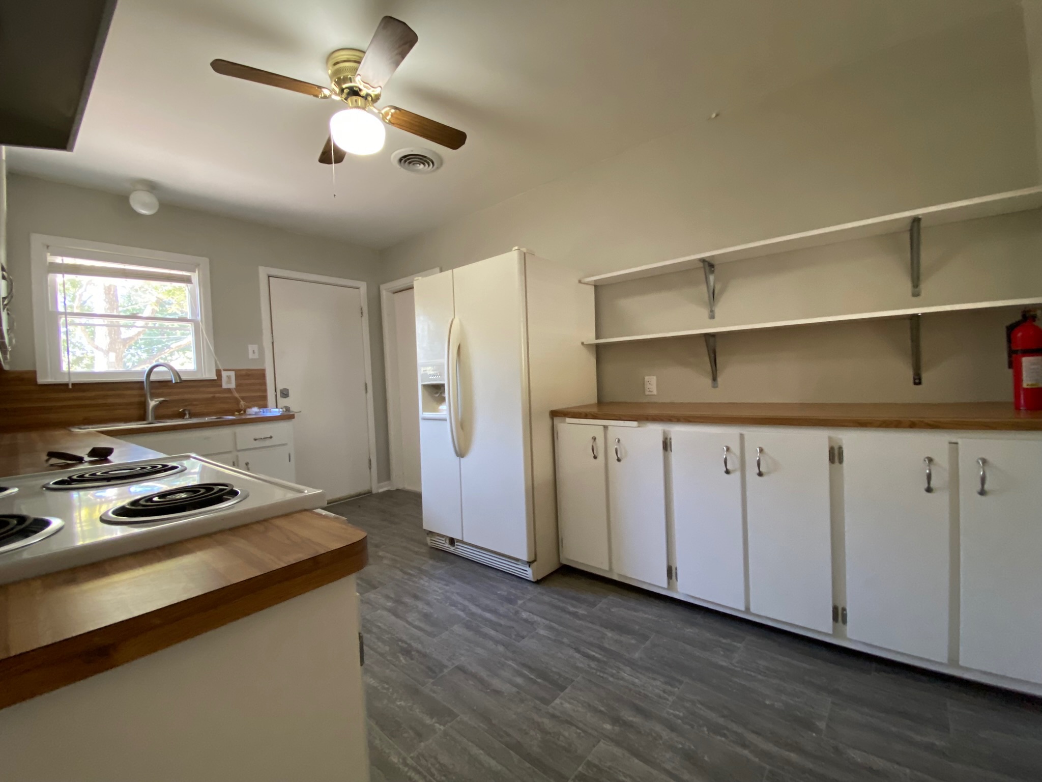 1818 South 39th Street Temple, TX 76504 - Photo 3 of 14 Kitchen with white cabinetry, open shelves, white fridge with ice dispenser, a ceiling fan, and butcher block countertops