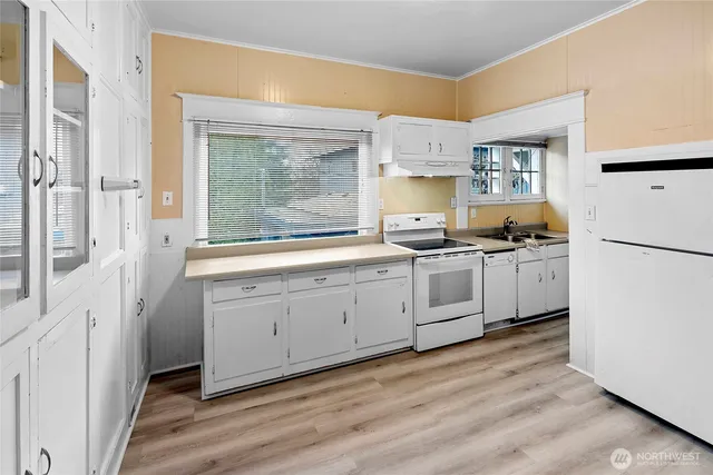 a kitchen with white cabinets and white appliances