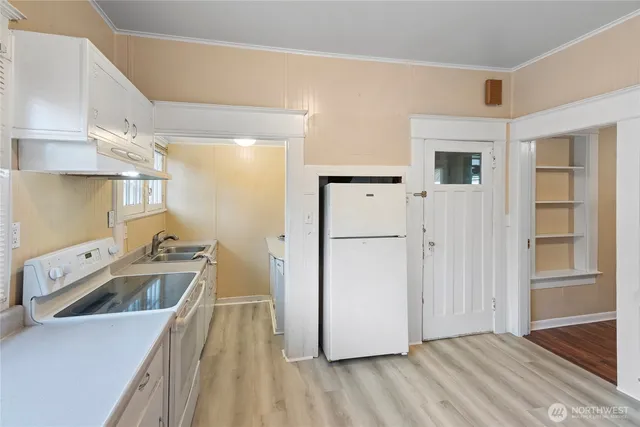 a kitchen that has a sink a stove and a refrigerator