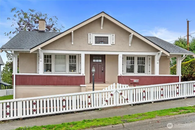 a view of a house with a small yard and wooden floor and fence