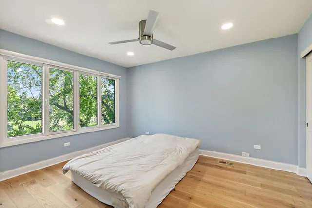 a bedroom with a bed and a large window