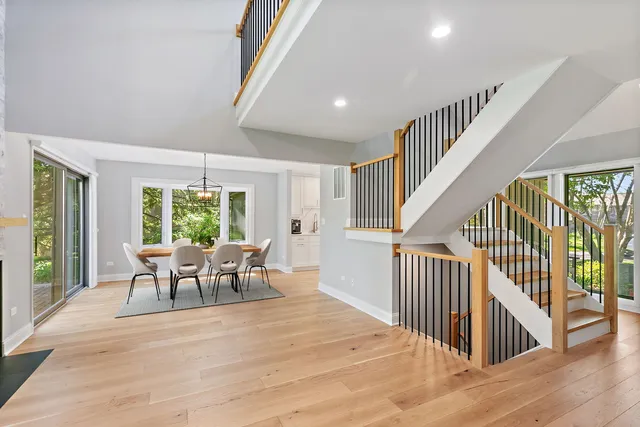 a dining room with wooden floor and windows