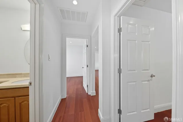 a view of a hallway with wooden floor