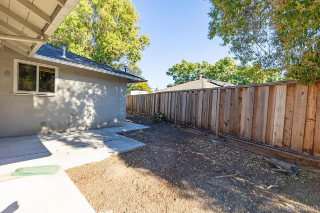 a view of a backyard with wooden fence