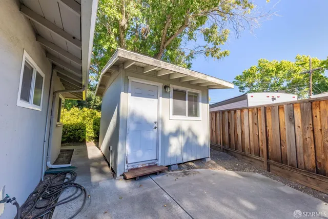 a view of a house with a yard and potted plants