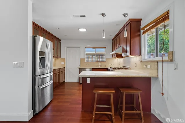 a kitchen with kitchen island a large counter top space appliances and a window