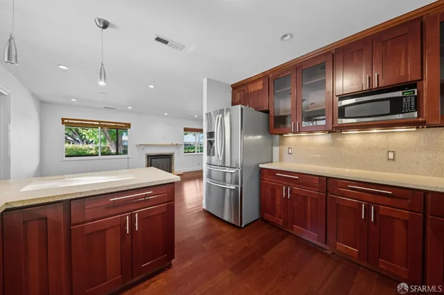 a kitchen with kitchen island wooden cabinets a refrigerator and a sink