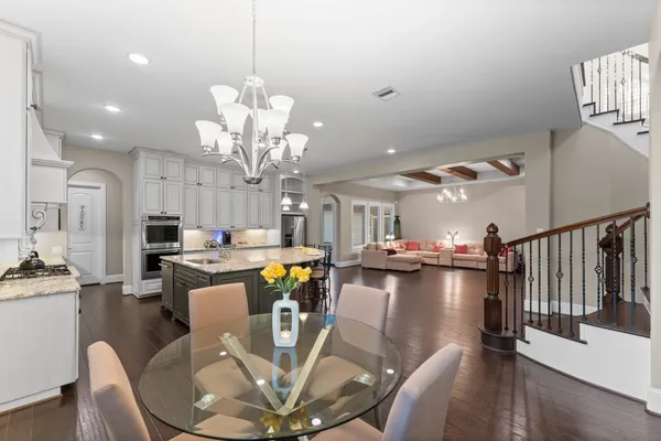 a view of a dining room with furniture a chandelier and wooden floor