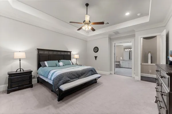 a spacious bedroom with a bed and a chandelier
