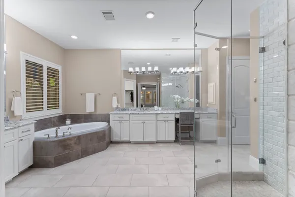 a bathroom with a tub a sink and mirrors