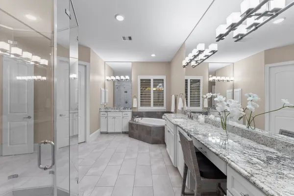 a large bathroom with a granite countertop sink a toilet a mirror and shower