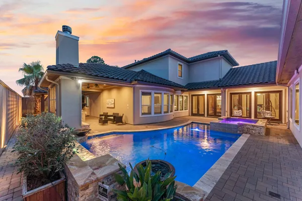a view of a house with pool and chairs