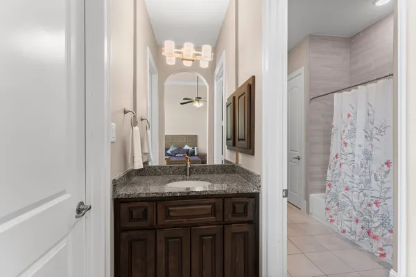a bathroom with a granite countertop sink a mirror and a shower