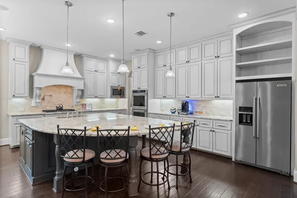 a kitchen with granite countertop a table chairs stove and cabinets