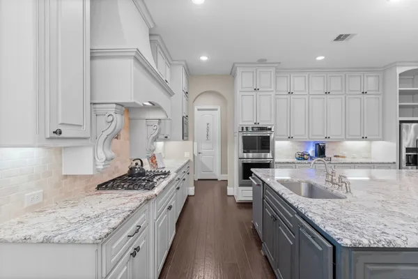 a kitchen with stainless steel appliances granite countertop a sink stove and refrigerator