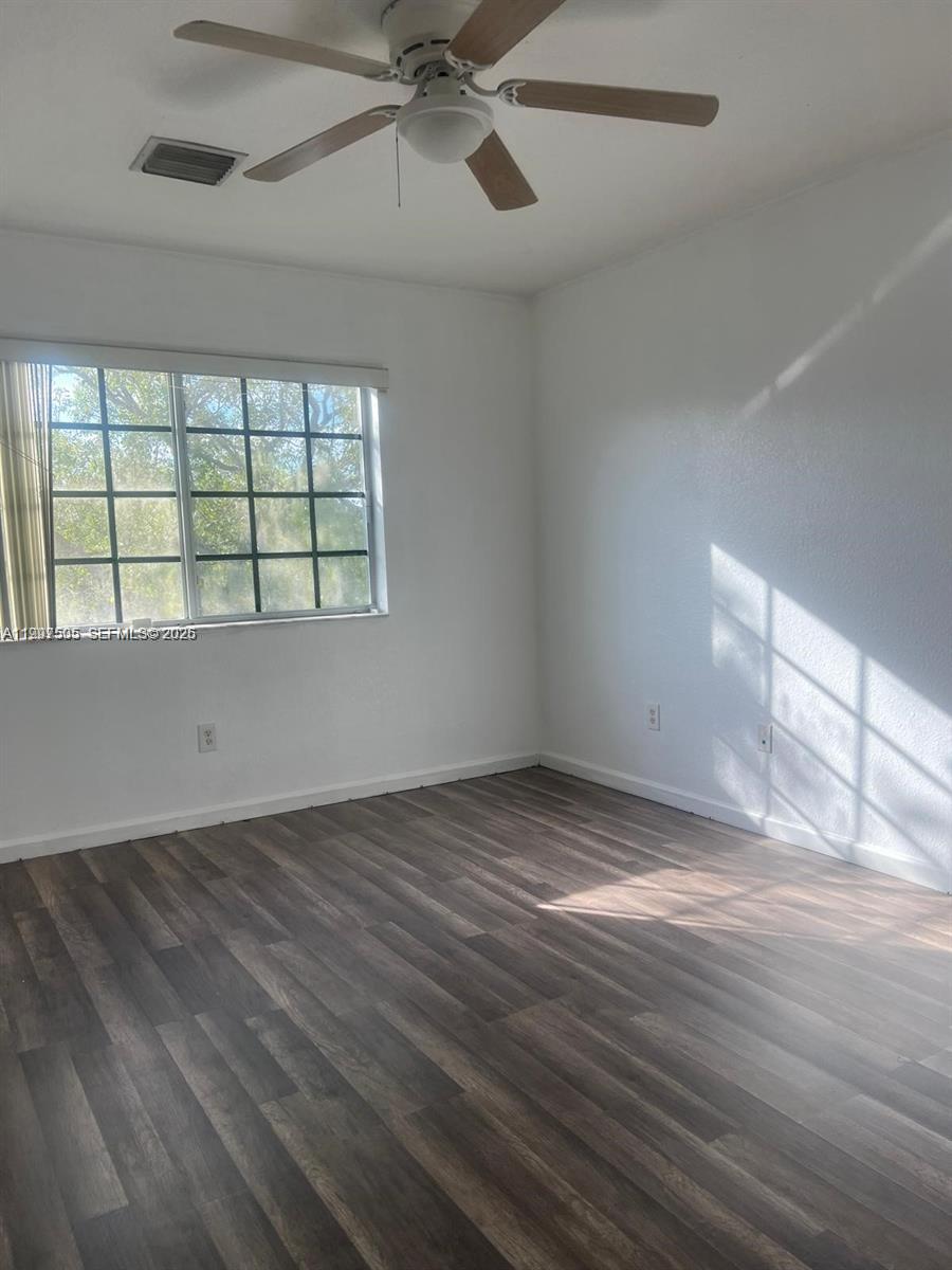 969 Abaco Lane Riviera Beach, FL 33404 - Photo 6 of 11 an empty room with wooden floor fan and windows