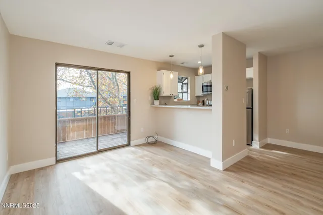 a view of a kitchen with wooden floor and windows