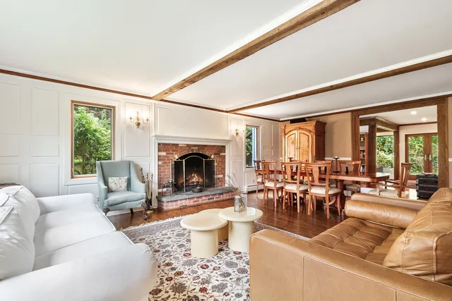 a living room with furniture large window and a fireplace