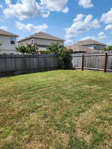 a view of a backyard with wooden fence